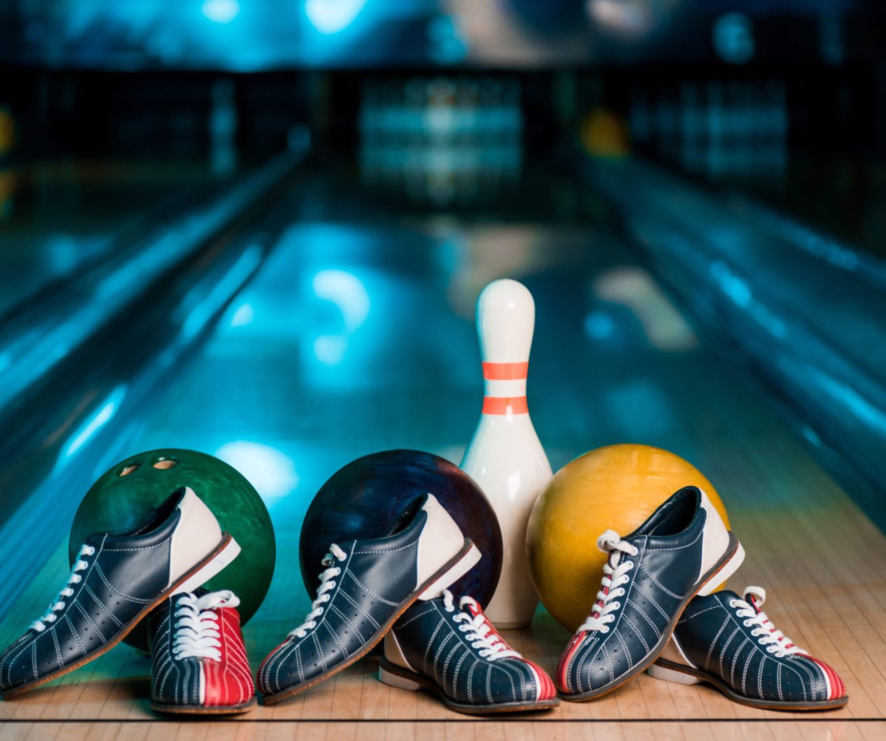 Drie bowlingballen en bowlingschoenen voor een bowlingkegel